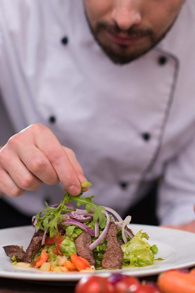 The chef at The Androy By Boomtown puts the finishing touches on a catered steak salad in Hibbing Minnesota.