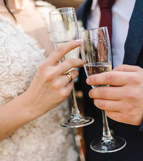 Champagne glasses clink at the Androy by Boomtown hosting a wedding reception for the happy couple in Hibbing MN.